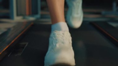 Spor ayakkabılı sporcu kadın spor salonunda koşu bandında koşuyor. Yoğun antrenman sırasında kızın bacakları. Sağlıklı koşu egzersizi.