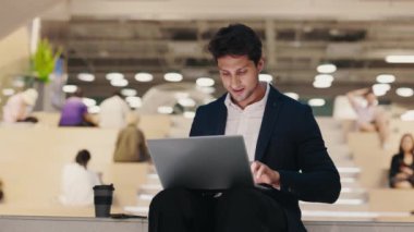 Genç İşadamı Lounge Area 'da oturuyor ve laptopta makale yazıyor. Yakışıklı Öğretmen Seminer ve Notlar İçin Dizüstü bilgisayarda Hazırlanıyor. Mesajlaşma, İnsanlarla Sohbet ve Teknoloji Konsepti