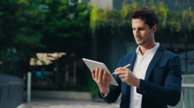 Dışarıdaki Resmi Giysiler 'deki Yakışıklı İş Adamı Tablet' te Dışardaki Dijital Kalemi Kullanıyor. Akıllı Yönetici Dijital Aygıtları Kullanarak Patron 'dan Uzaktan Görevler Yapıyor. Halk ve Teknoloji Konsepti