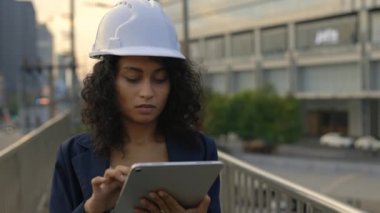 Genç Kıvırcık Saçlı Kadın Müfettişi İnşaat Alanı İnşa İncelemesi Koruyucu Veri, Ayakta Durma ve Kayıt Verileri Tablet 'te. Güzel Mimar Sayısal Aygıtla Sitede Çalışıyor