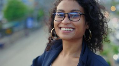 Kameraya gülümseyen, Blazer giysili genç bir iş kadını. Dışarda Güzel Kıvırcık Saçlı Kız Yönetici Pozu. İnsanlar Konsepti