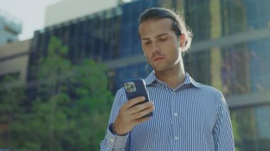 Adam, dışarıda, parkta beklerken telefonundan harika haberler alıyor. - Ne? Evet, Kafkasyalı iş adamı cep telefonu tutuyor ve dışarıda zaferini kutluyor. Halk ve Zafer Konsepti