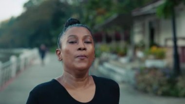 Kilo vermek için çabalayan çok ırklı Yetişkin Kadın. Aşırı kilolu kadın koşucu dışarıda koşuyor. Halk ve Spor Konsepti