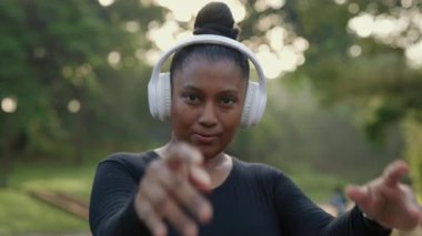 Parkta beklerken kulaklıkla dans eden güzel kız tatmin oldu. Fazladan Kilolu Neşeli Kadın Müzik Dinliyor ve Eğleniyor. Halk ve Teknoloji