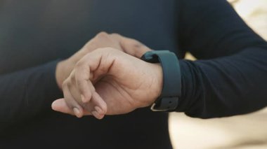 Koşudan sonra dijital akıllı saat kullanan bir kadının elinin yakın çekimi. Maratondan Önce Genç Koşucu, Açık havada dururken Saati Bileğine Ayarlıyor. Halk ve Teknoloji