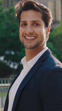 Dikey video. Mutlu Gülümseyen Güzel Adam dışarıda, resmi kıyafetini giymiş ve kameraya bakıyor. Başarılı Genç Yöneticinin Dışardaki Portresi. İnsanlar Konsepti