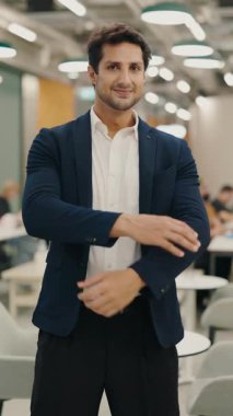 Dikey video. Başarılı Genç İş Adamı 'nın Portresi Ayakta Duran ve Çapraz Eller, Resmi Giysiler Giyen. Yakışıklı Adam Yöneticisi Ofis AVM 'deki Kameraya Poz Veriyor.