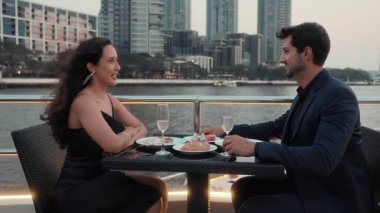 Romantik İspanyol çiftin portresi şampanya bardaklarını tokuşturup lüks bir yatta yemek yiyor. Mutlu Latin Amerikalı erkek ve kadın deniz yolculuğunun evlilik yıldönümünü kutluyor