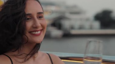 Sarkık küpeli güzel Latin kadın portresi yat güvertesinde şarap içiyor. Gevşemiş İspanyol bayan, Tayland 'da alacakaranlıkta deniz yolculuğunda lüks içkilerden hoşlanır.