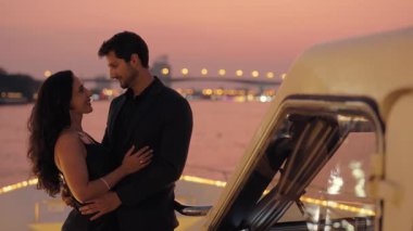 Lüks bir yatta kokpitin yanında öpüşen Latin Amerikalı çiftin portresi. Romantik İspanyol erkek ve kadın Tayland 'da motorlu tekne ile seyahat ederken tutkularını ifade ederler.