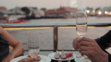 Romantik ortaklar, lüks bir yatta yemek yerken kadeh tokuşturup pahalı şaraplar içiyorlar. Genç çift yıl dönümünü kutluyor. Akşamları modern gemiyle denize açılıyorlar.