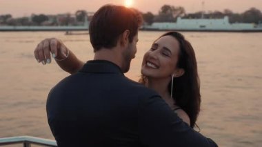 Gülümseyen Latin Amerikalı kadının portresi gün batımında yatta duran erkek arkadaşına sarılıyor. Pozitif İspanyol kız arkadaşı Tayland 'da deniz yolculuğunda partnerine aşkını gösteriyor.