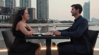 Latin Amerikalı bir kadının portresi romantik bir yatta sevgilisiyle kadeh tokuşturuyor. İspanyol çift, akşamları gemiyle deniz yolculuğunu kutluyor.