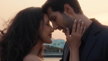 Gün batımında yatta, sevimli Latin kadın ve erkeğin alınlarına dokunarak öpüşmelerinin portresi. İspanyol ailenin Tayland 'da deniz yolculuğunun keyfini çıkardığı romantik balayı atmosferi.