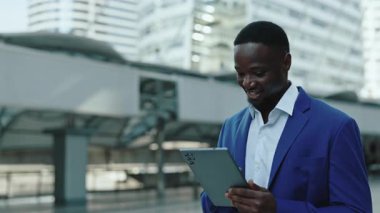 Duygusal Afrikalı Amerikalı tüccarların portresi açık havada dijital tablette döviz kuru derecesi. Şaşırtıcı sakallı iş adamı şehir merkezinde ticari teklif alıyor.