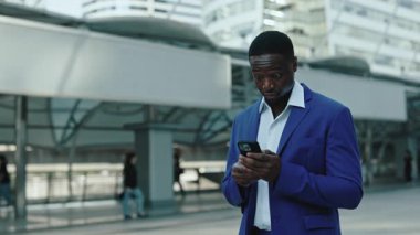 Neşeli Afrikalı Amerikalı girişimci portresi ofis binasında karlı bir anlaşma yapıyor. Şirket sakallı çalışanı, Megapolis bloğunda akıllı telefon bulundurduğunu açıkladı.