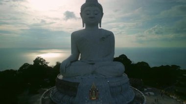 Phuket Big Buddha dağda meditasyon yapan heykel günbatımı gökyüzü manzarasına karşı. Budizm 'in aziz sembolü egzotik adada turistleri ve yerlileri meşgul ediyor. Asya kültürü keşfediyor