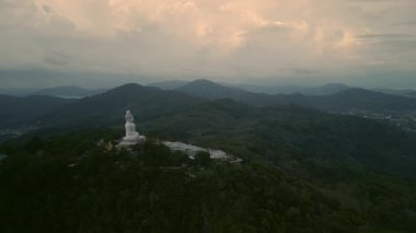 Phuket heykelinin büyük Buda heykeli dağların tepesinde sakince oturuyordu. Budizm, tropikal bölgelerdeki gelenekler için dua ediyor. Tayland Kültür Mirası
