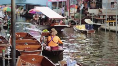 Damnoen Saduak, 5 Haziran 2025: Tayland 'ın kalabalık yüzen pazarında, otantik kültürel yaşam tarzı sahnesinde satıcılarla ve turistlerle geleneksel ahşap botlar.