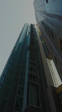 Finans bölgesinde yansıtıcı cam ve çelik cepheli yüksek fütürist gökdelenlerin dipteki görüntüsü. Kurumsal büyüme kavramı, modern iş mimarisi, yenilik ve küresel finans.