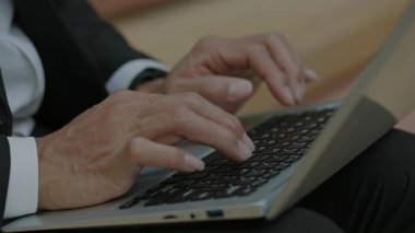 Yetişkin erkek ellerinin şehir sokaklarında dizüstü bilgisayarda klavye kullanması. Deneyimli bir ofis çalışanı şirket işyeri dışındaki taşınabilir bilgisayara finansal rapor yazar.