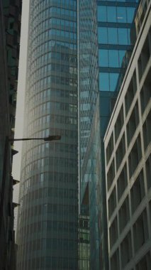 Modern multistory buildings with stylish facades in business downtown vertical shot. Corporate company headquarters location in megapolis setting. Asian urban architecture