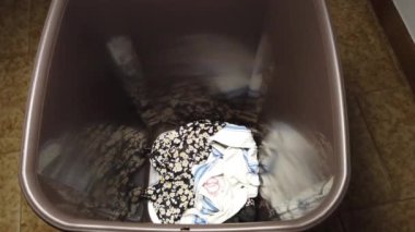 Kirli çamaşırları plastik bir kutuya koyan bir adam. Yüksek kalite 4k görüntü