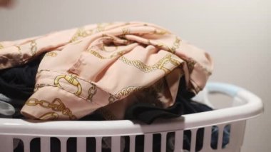 Bir adam çamaşırları plastik sepetten ütülemek için alır. Yüksek kaliteli FullHD görüntüler