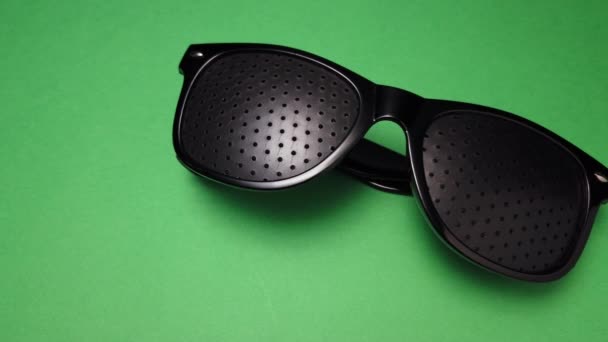 Czarne Okulary Perforowane Otworami Izolowanymi Zielonym Tle Szklanki Perforowane Okulary — Wideo stockowe