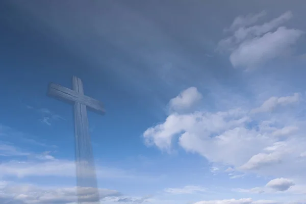 A wooden Christian cross with bright sun and clouds.