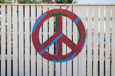 Plajın çitlerine beyaz barış sembolü çizilmiş.