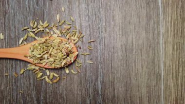Fennel granules on a wooden spoon. Food spices. Fresh and diet spice concept for vegan cooking schools and diet products. High quality 4k footage