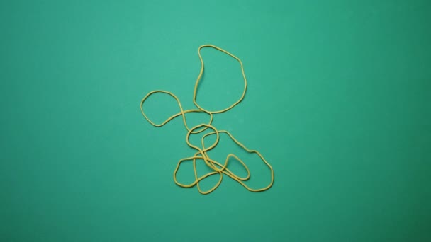 Yellow Office Rubber Bands Fall Green Surface High Quality Footage — Stockvideo