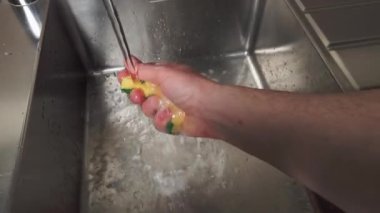 Evini enerjik bir şekilde toparlayan, kollarını hareket ettirerek suyun altında sünger sıkan biri. Yüksek kalite 4k görüntü