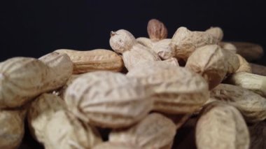 Siyah arka plandaki lezzetli fıstıklar sağlıklı beslenmeyi ve refahı sembolize eder. Yüksek kalite 4k görüntü