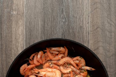 Ahşap zemin üzerinde taze pişmiş portakal karidesli pişirme tepsisi.