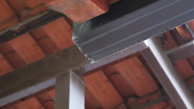 Su damlaları saçağın çatısına taşar, yağmurlu bir günde doğal afet olur. Yüksek kalite 4k görüntü