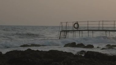 Footbridge. Bridge over the sea. The exceptional construction of the pier goes towards the open sea and the horizon on a sunset afternoon. High quality 4k footage
