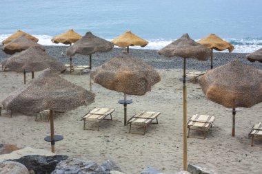 İtalya 'nın Campania kentindeki Palinuro plajındaki tropik şemsiye bir turizm konseptine işaret ediyor