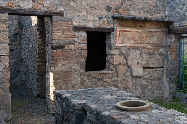 Pompeii, Italy-April 27, 2024: Pompeiis Interior. Era-Painted Walls and Food Storage Jar in the Foreground of a Dwelling.