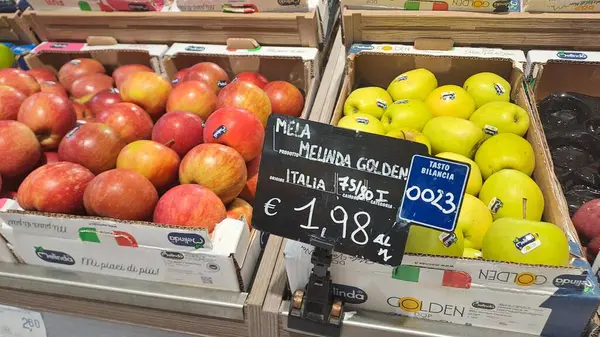 Roman, İtalya - 29 Nisan 2025: Signboard ile Süpermarket Rafında Vibrant Olgun Elmalar Ayarlandı