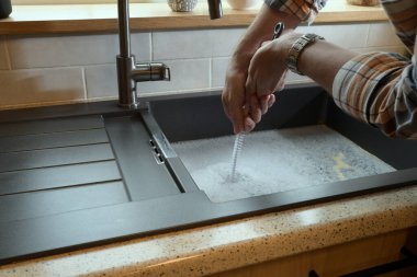 Tıkanmış lavabo, tıkanmış lavabo, su tesisatı sorunları, açılmaya çalışılıyor.