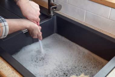Tıkanmış lavabo, tıkanmış lavabo, su tesisatı sorunları, açılmaya çalışılıyor.