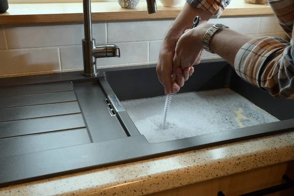 Tıkanmış lavabo, tıkanmış lavabo, su tesisatı sorunları, açılmaya çalışılıyor.