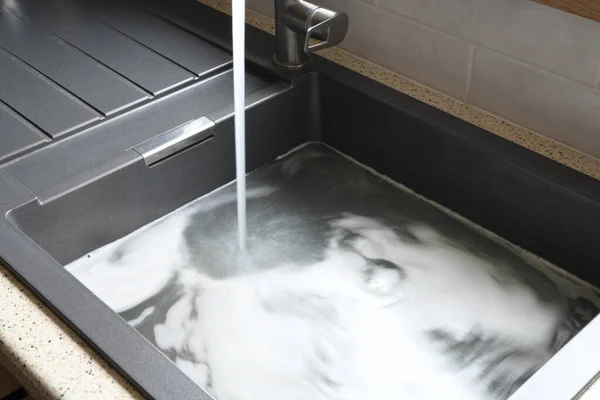 Tıkanmış lavabo, tıkanmış lavabo, su tesisatı sorunları, açılmaya çalışılıyor.