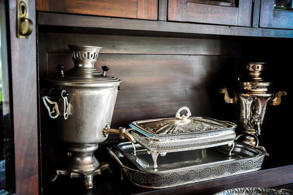 Silver tea set on a tray reflected on its surface a living room, antique stuff