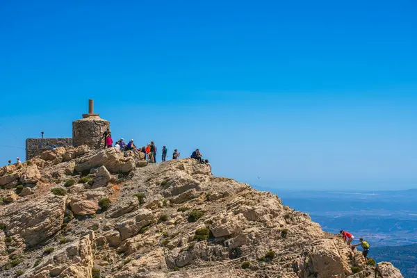 西班牙Penyagolosa 2024年4月14日徒步旅行者在佩尼亚戈罗萨山顶上休息 佩尼亚戈罗萨山是瓦伦西亚地区最具象征意义的山 免版税图库图片