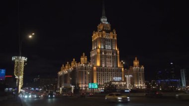 Moskova, Rusya, 4 Aralık 2024. Ukrayna Oteli 'nin önündeki trafik gece aydınlandı. Sovyet lider Joseph Stalin tarafından yaptırılan Yedi Kız Kardeş Gökdelenleri' nden biri.