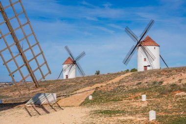 Beyaz yıkanmış, ahşap bıçaklı iki geleneksel İspanyol yel değirmeni Mota del Cuervo, La Mancha, İspanya 'da dimdik ayakta