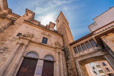 Güneş ışığı, İspanya 'nın Castellon Eyaleti' ndeki Segorbe Katedrali 'nin tarihi ön cephesini ve çan kulesini aydınlatarak geleneksel İspanyol mimarisi ve taş malzemelerini ön plana çıkarmaktadır.